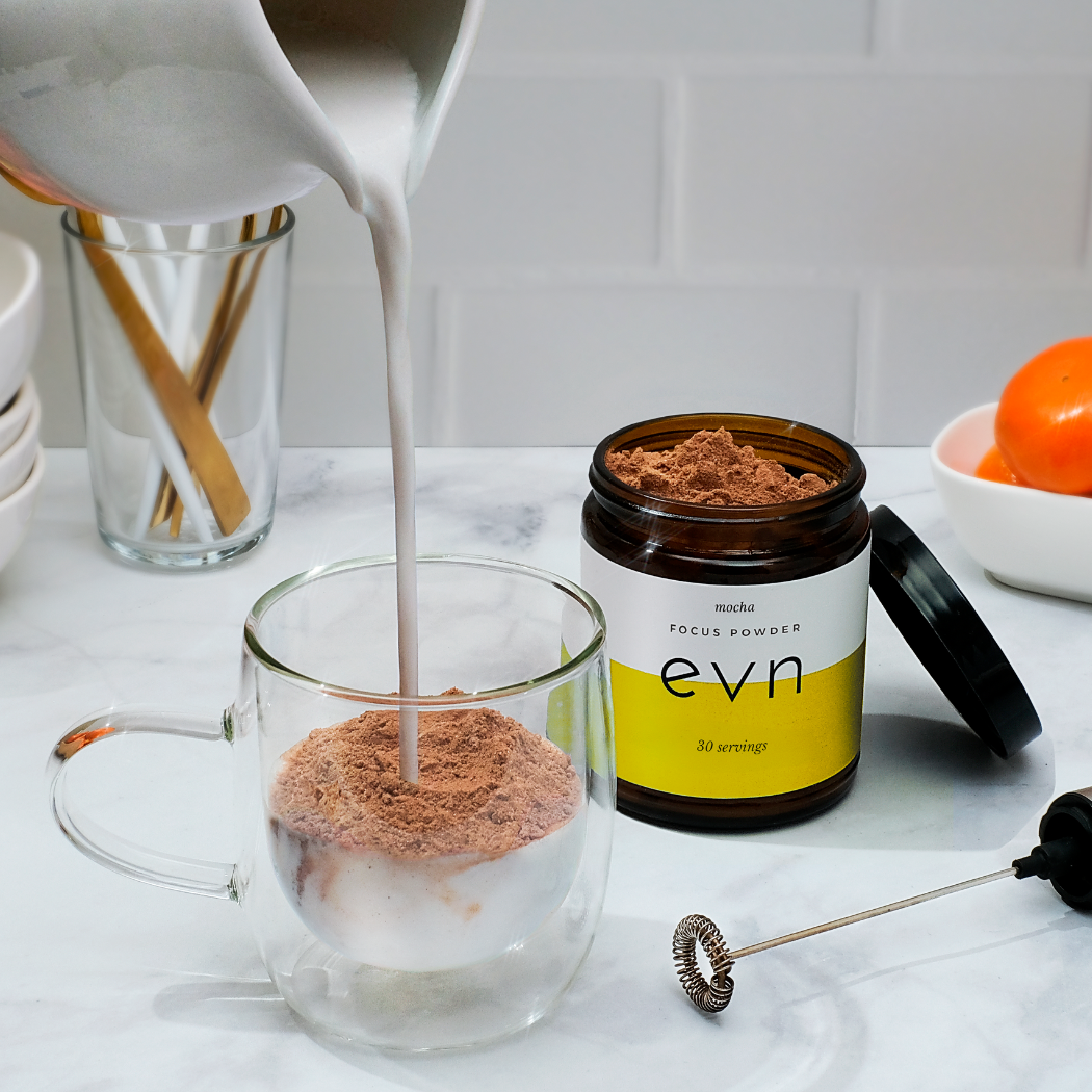 milk pouring into a lass with mushroom powder in it